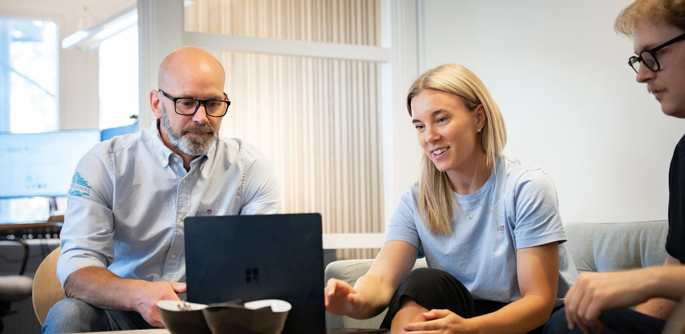 Medarbetare på GoProfessional samlade kring en bärbar dator