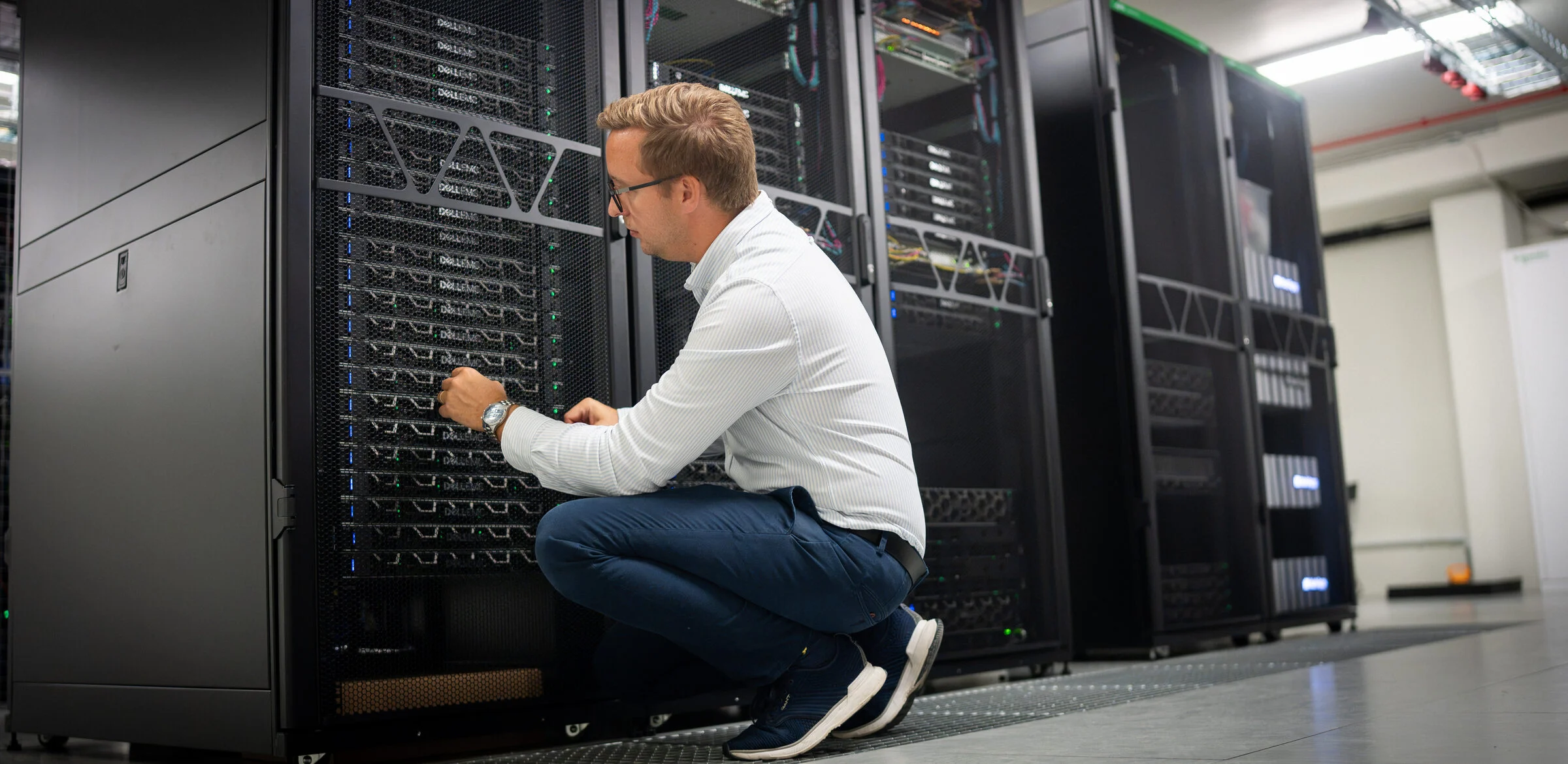 Tekniker arbetar vid serverrack i en datahall