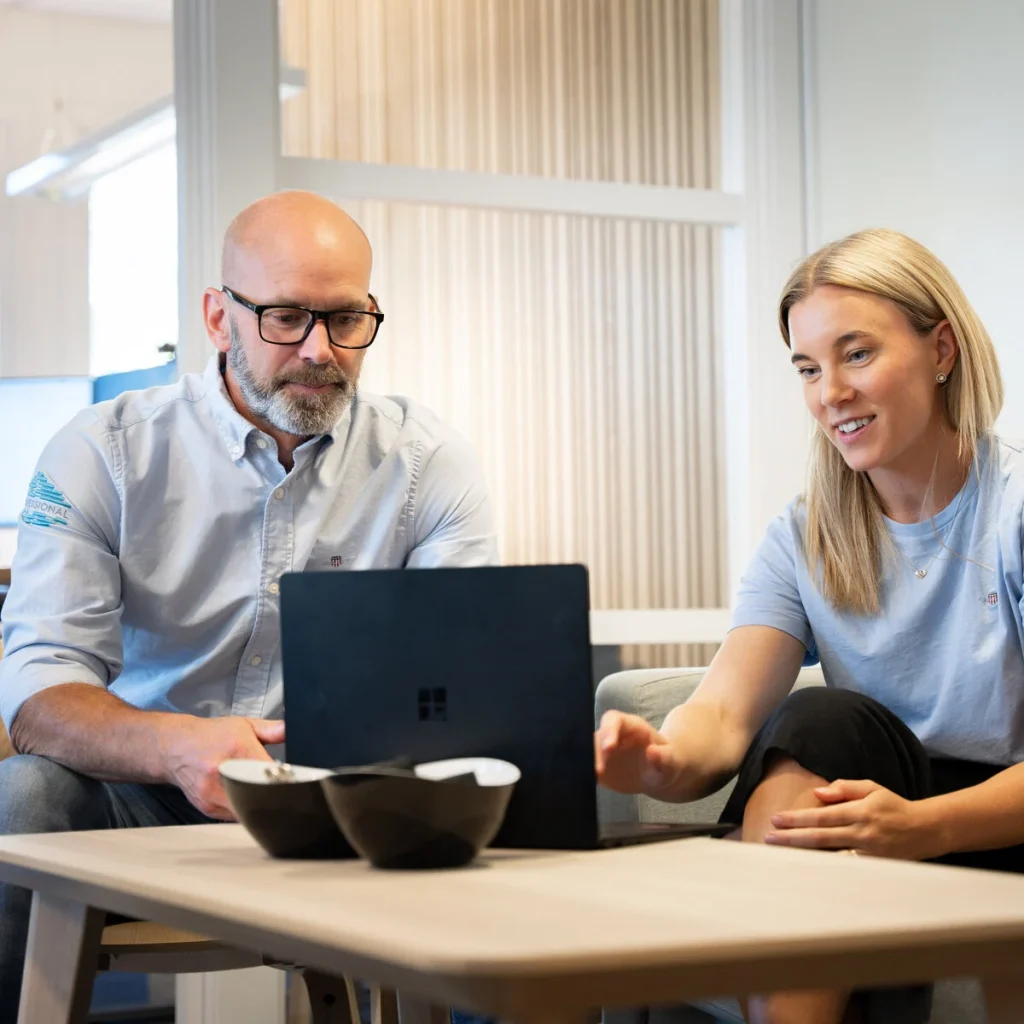 Två medarbetare på GoProfessional går igenom ett ärende vid en bärbar dator