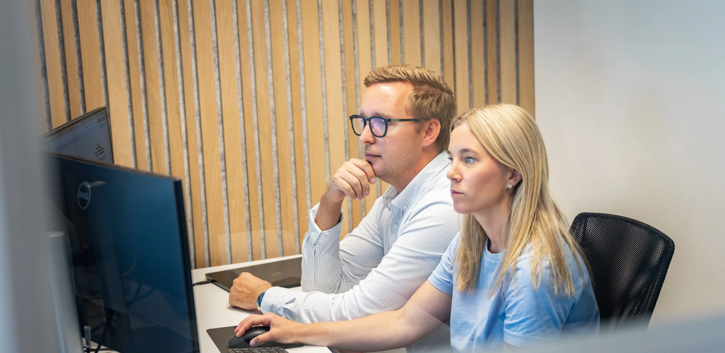 Två medarbetare arbetar tillsammans framför en skärm