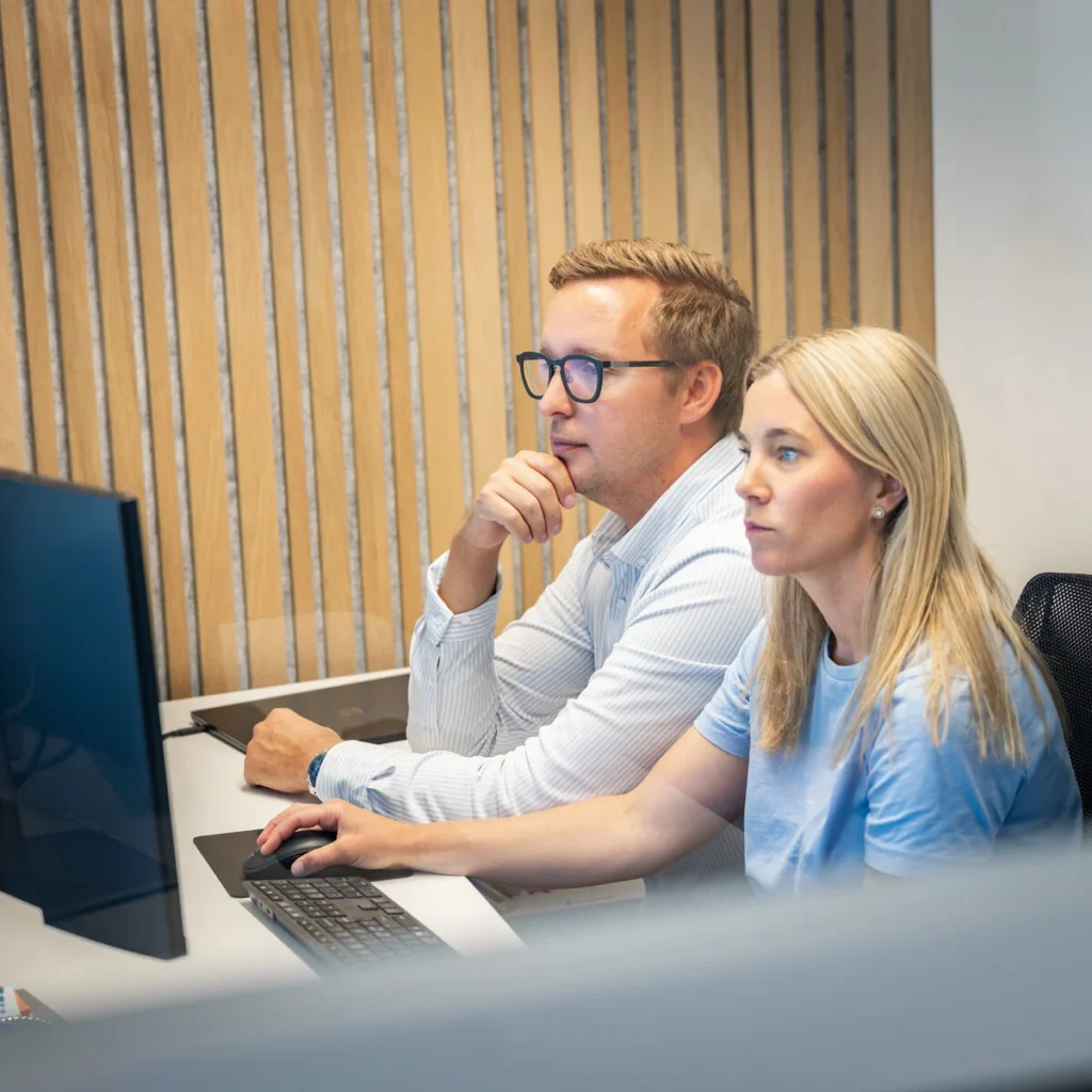 Två medarbetare arbetar tillsammans vid en dator