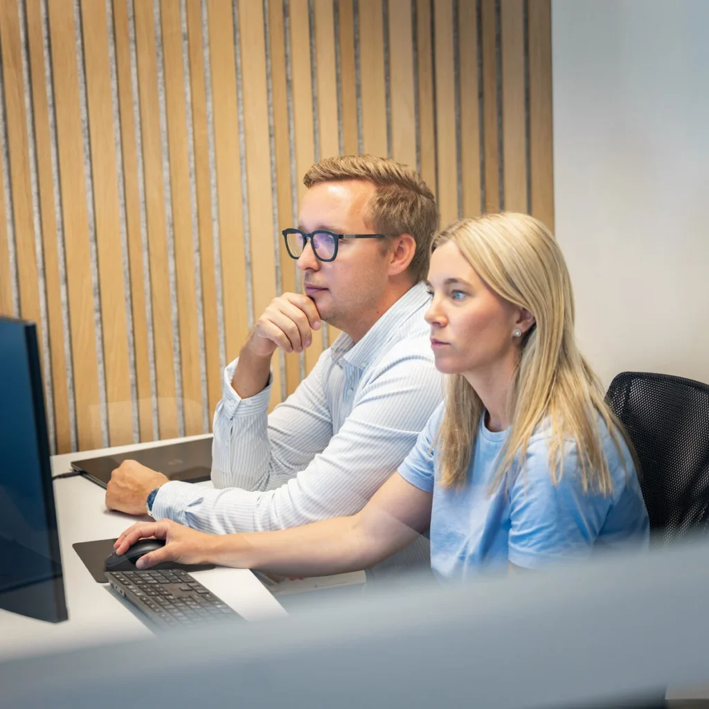 Två medarbetare arbetar tillsammans vid en dator